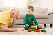 © Prostock-studio - Boy playing with grandfather in building kit
