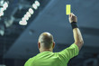Referee shows yellow card during handball match.