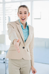 Poster - Happy young businesswoman reaching her hand friendly