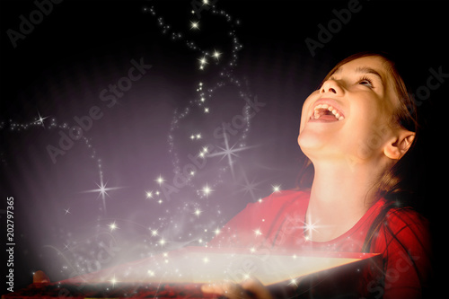 Fotografía Little girl opening a magical christmas gift against snow