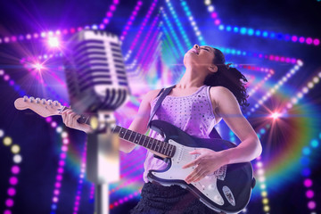 Poster - Pretty girl playing guitar against digitally generated star laser background