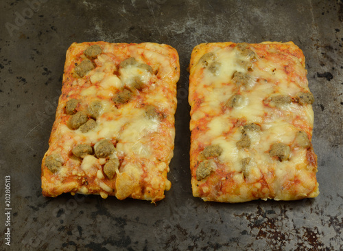 Valokuva Rectangular sausage and cheese pizza pieces on on flatbread on weathered baking