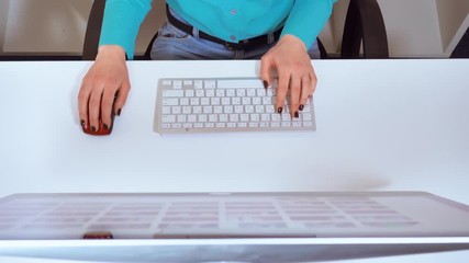 Leinwandbilder - details top view unrecognizable woman sitting at the white desk in front of display typing on keyboard and using pc mouse