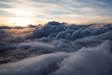 Wall Mural - Beautiful and striking aerial view of the puffy clouds during a colorful sunset. Taken near Vancouver, British Columbia, Canada.