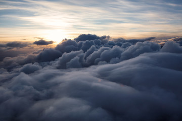 Wall Mural - Beautiful and striking aerial view of the puffy clouds during a colorful sunset. Taken near Vancouver, British Columbia, Canada.