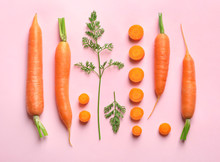 Flat lay composition with fresh carrots on color background