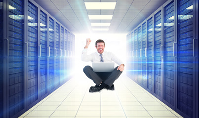 Poster - Businessman using laptop and cheering against digitally generated server room with towers