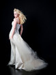 © faestock - full length portrait of woman wearing white bridal gown. standing poison black studio background.