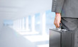 © vectorfusionart - Businessman holding briefcase against bright white room with columns