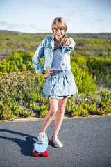 Poster - Attractive blonde on her skateboard pointing at camera