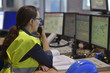 © goodluz - Woman in industrial control room using radio to give instructions