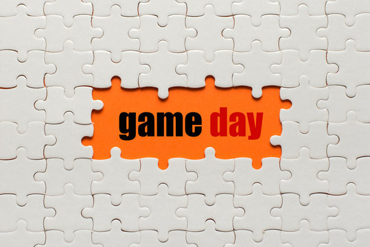 White details of puzzle on orange background and word Game Day