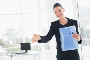 Poster - Elegant businesswoman offering a handshake in office