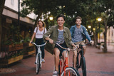 Fototapeta  - Young friends cycling in the city