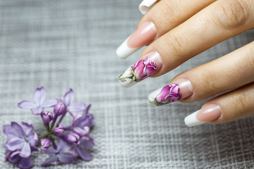 Beautiful multicolored flowers on a transparent lacquer on the nails