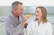 © WavebreakmediaMicro - Man feeding woman orange slice in kitchen