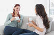 © WavebreakmediaMicro - Female friends enjoying a chat over coffee at home