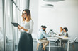 © BGStock72 - Elegant businesswoman standing in office with digital tablet