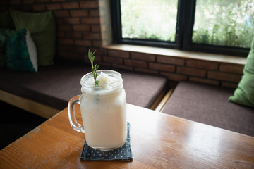 Wall Mural - coconut water frappe with rosemary leaf on restaurant table