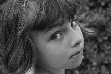 Black and white portrait of a young girl looking over her shoulder