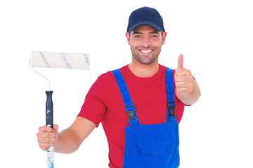 Poster - Smiling handyman with paint roller gesturing thumbs up