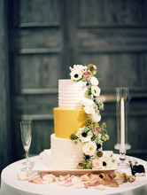 Decorated Tiered Wedding Cake With Champagne Flute And Candle