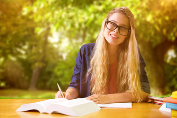 Wall Mural - Student studying in the library  against trees and meadow in the park