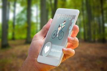 Poster - hand holding smartphone against tree trunks in the forest