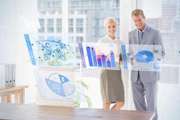 Leinwandbilder - Digitally generated image of pie chart and bar graph against smiling business partners looking at camera
