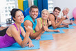 © WavebreakmediaMicro - People gesturing thumbs up while lying on mats at gym