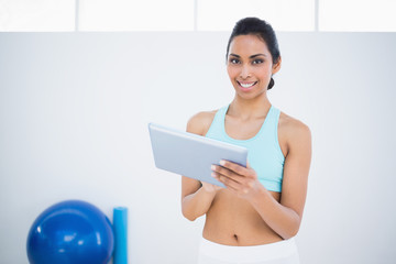 Poster - Content beautiful woman in sportswear holding her tablet