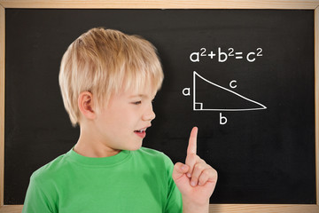 Composite image of cute boy pointing against blackboard 