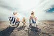 © Mediteraneo - Couple on a deck chair relaxing on the beach. Happy couple enjoy on the beach during summer vacations