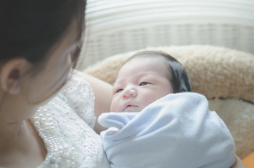 mother is holding her sleeping newborn baby
