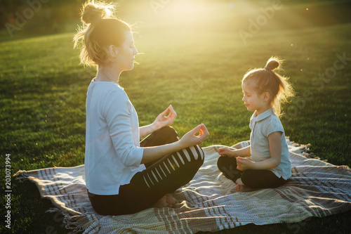 Fotografía Mother practicing yoga with her daughter in the open air.