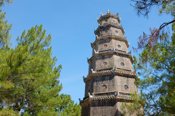 ancient asian tower amd greem trees under the blue sky