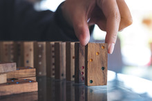Closeup Image Of A Woman Putting Wooden Domino Game In Order On Table