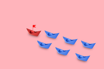 Red paper ship leading in pastel backgroundå