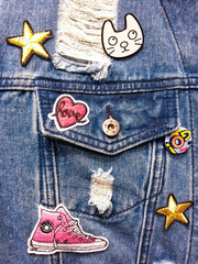 vintage denim texture background: jacket close-up with pocket and colorful decor. patches, embroider