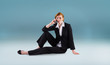 © vectorfusionart - Redhead businesswoman on the phone against blue vignette background