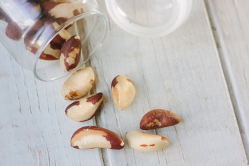 Poster - Brazil nuts and glass bottle over the white table