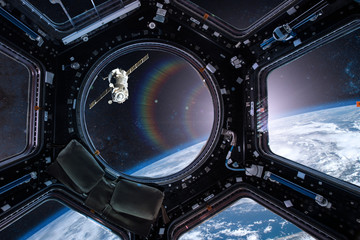 Wall Mural - view from a porthole of space station on the earth background. elements of this image furnished by n