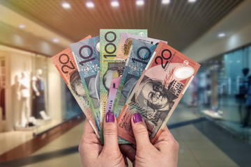 Closeup of female hands with australian dollar in shopping mall