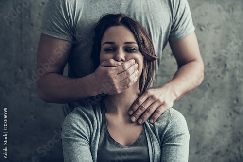 Fotografía Man closes by hand mouth of oppressed woman.