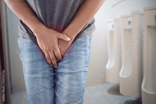 Fotomural Asian man wants to pee and is holding his bladder.