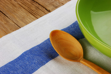 Wall Mural - wooden spoon with a plate on the table cloth on an old wooden table