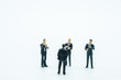 © Montri Thipsorn - Business and Communication concept. Group of businessman miniature figures standing and meeting on white background.