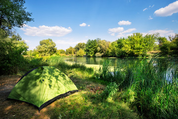 Wall Mural - green tent on the river bank