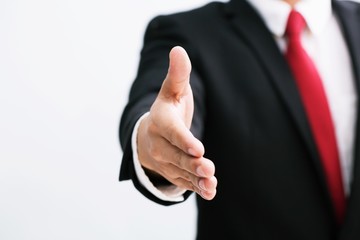 Wall Mural - Business man in suit and red necktie  open hand ready to seal a deal, hold out one's hand partner shake hands, copy space. white background.