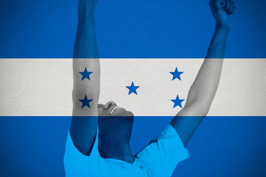 Excited handsome football fan cheering against honduras national flag